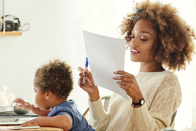 mom working on paper, baby nearby