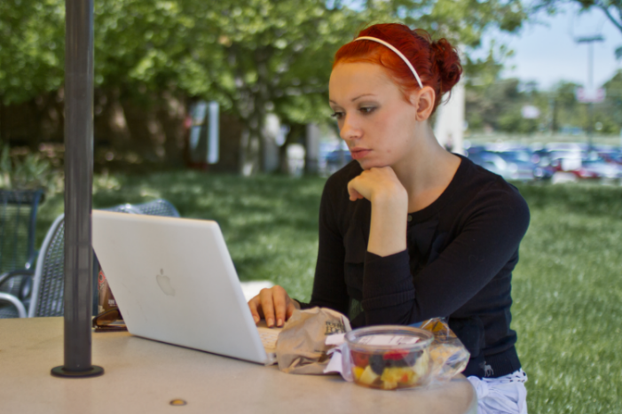 student sitting outside at table