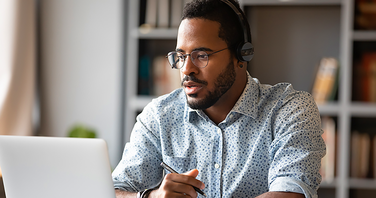 african american male sitting in front of laptop