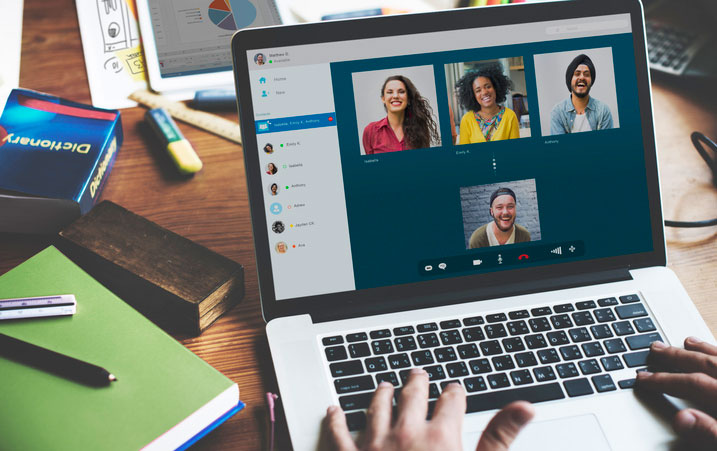 person in conference with others on laptop