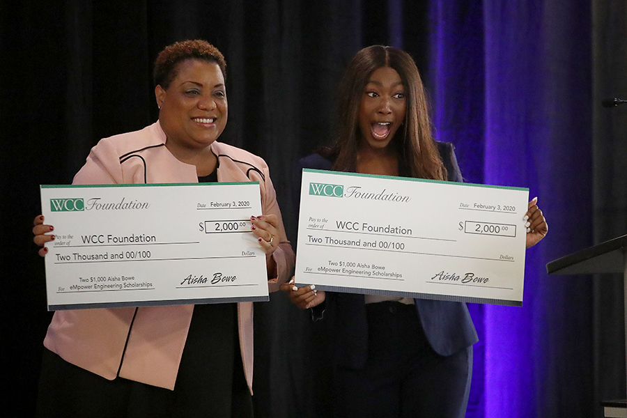 Aisha Bowe and Kim Hurns holding checks to WCC Foundation from Bowe