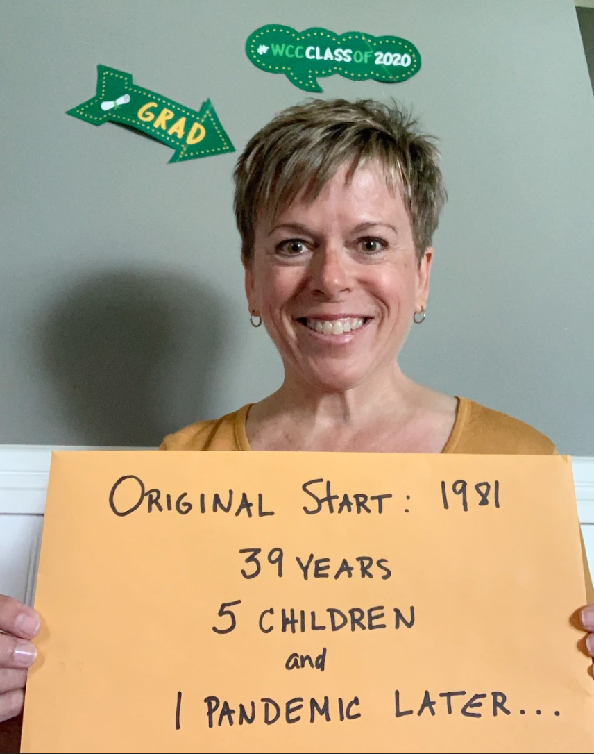 Sandra Coward holding graduation sign