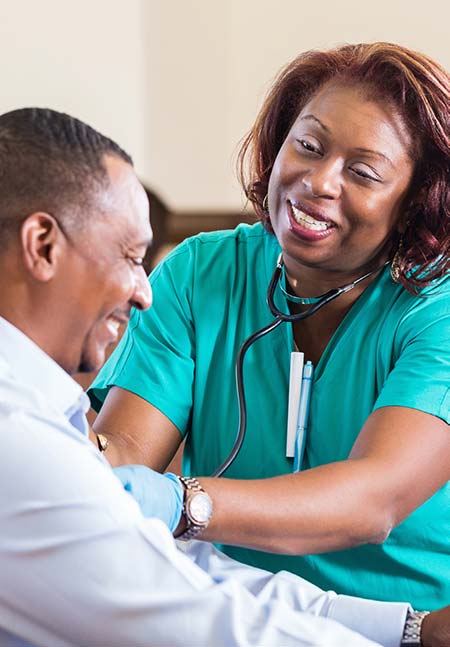 Smiling Health care worker taking patient's vital signs