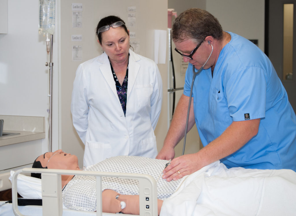 Longtime nursing faculty instructor Gloria Velarde supervises WCC nursing student Jim Abraham as he diagnoses a “patient dummy.” (Photo by Jessica Bibbee)