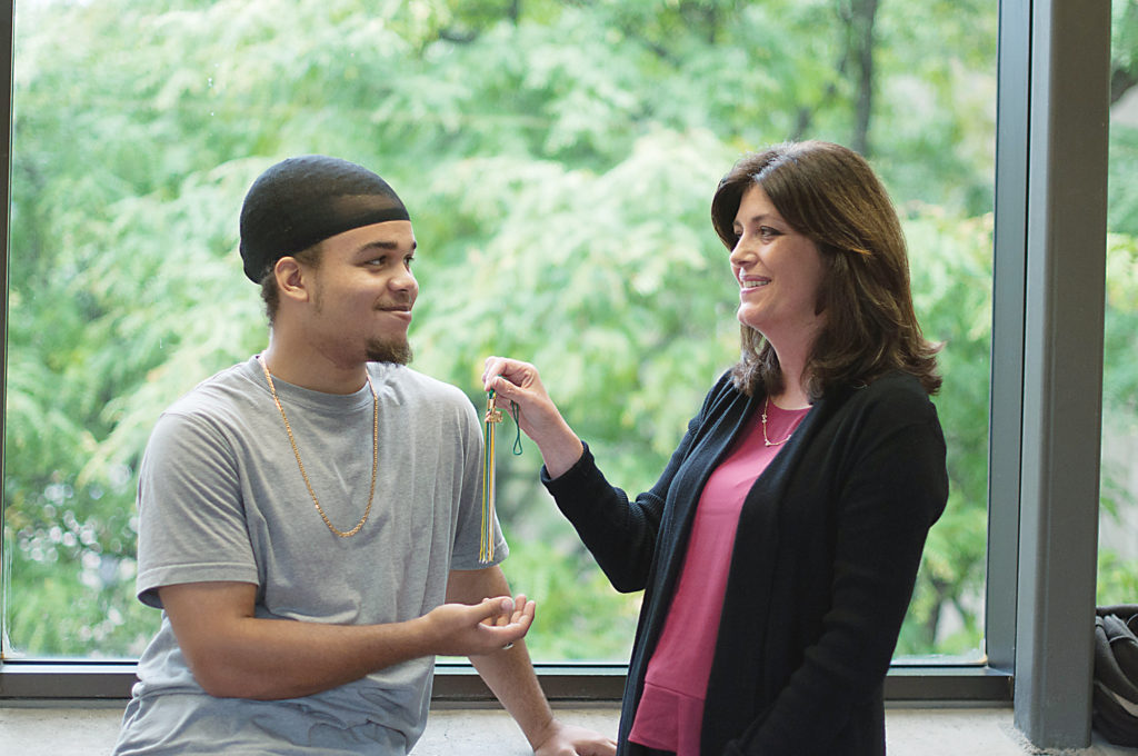 REACH Coordinator Kathy Stewart (right) and WCC student and REACH participant Indyo Anderson share a moment and examine his graduation tassle, which he earned through the Adult Transitions Program. (Photo by Jessica Bibbee)