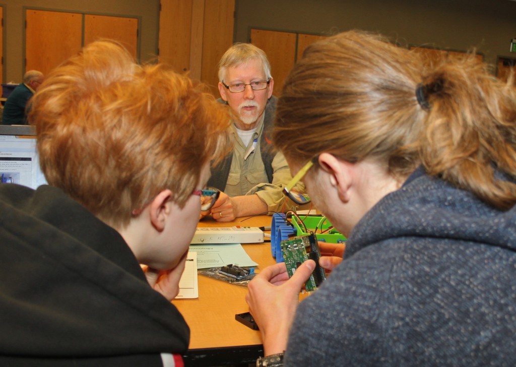 Manchester High School science teacher Mark West watches students Gi West, right, and Jakob Rosskopf examine computer components of what will become the model of an autonomous vehicle. Photo by Lynn Monson