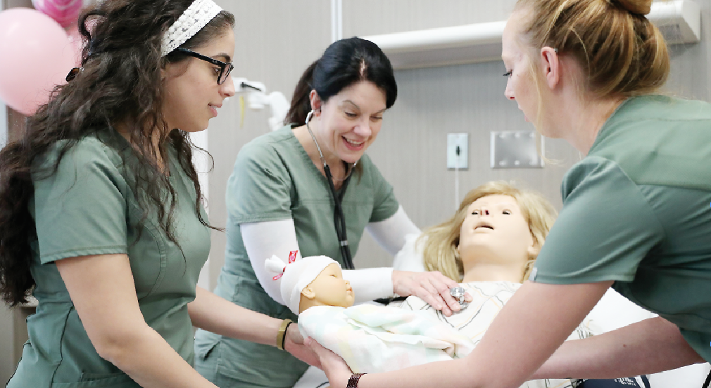 Nursing students tend to a birthing simulator and its newborn baby inside a new Washtenaw Community College nursing lab. | Photo by Kelly Gampel