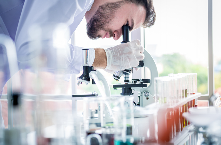 man looking through microscope